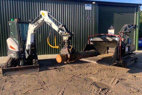 Dobells Professional Tree Care & Arboricultural Contractors | Crane Assisted Tree Work | Equipment putting a trunk into chipper